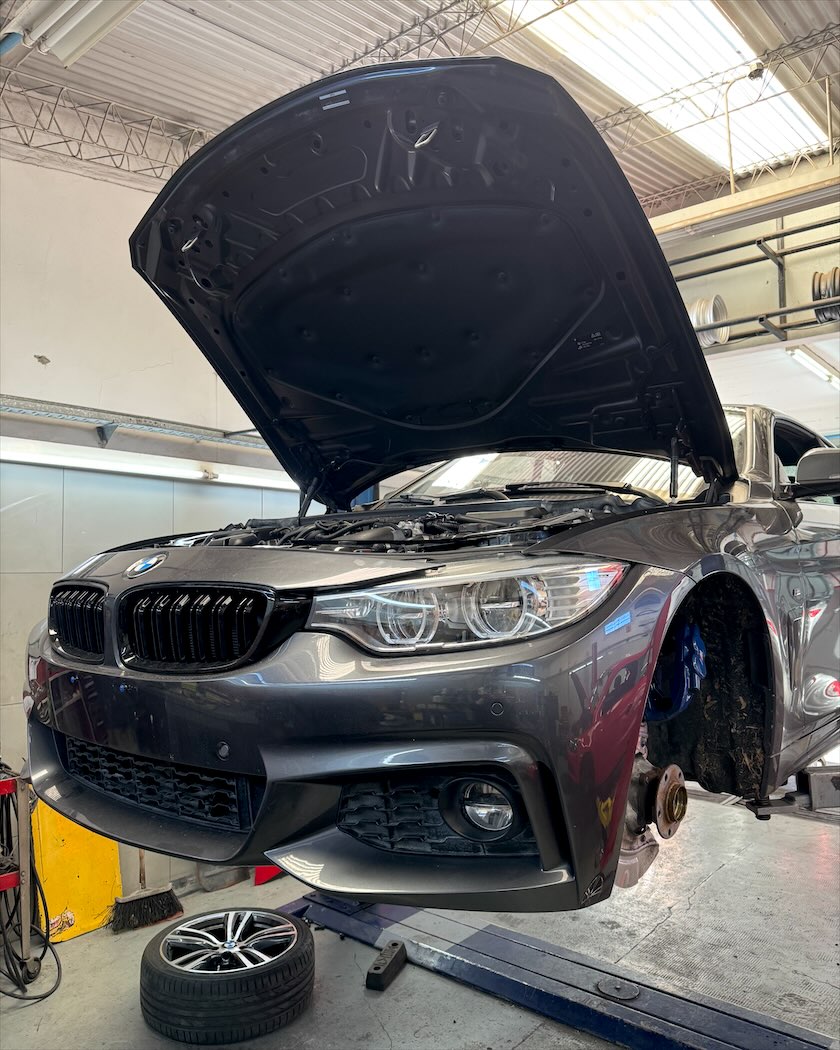 BMW Serie 4 levantado en el elevador, sin la rueda delantera